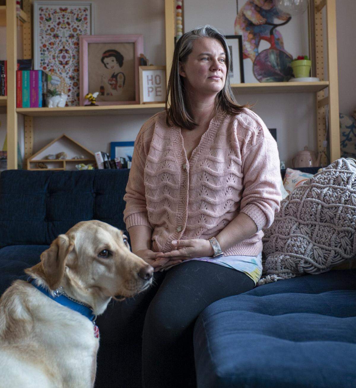 Alicia Steele sits with her son’s service dog, Buckeye, in their home in O’Fallon near Scott Air Force Base in February. Steele has moved five times in the 16 years she’s been married to her husband, a pilot in the Air Force.