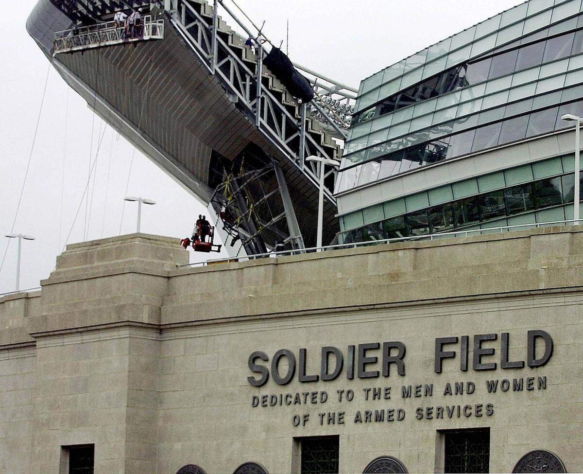 Construction workers put the finishing touches on parts of the reconstructed Soldier Field on Aug. 12, 2003, in Chicago. Soldier Field was named as such at the request of Gold Star Mothers to honor the men lost in World War I. The nearby benches for moments of reflection contain notable quotations about service to country and actual Armed Forces Medals of Honor cast into the backrests.