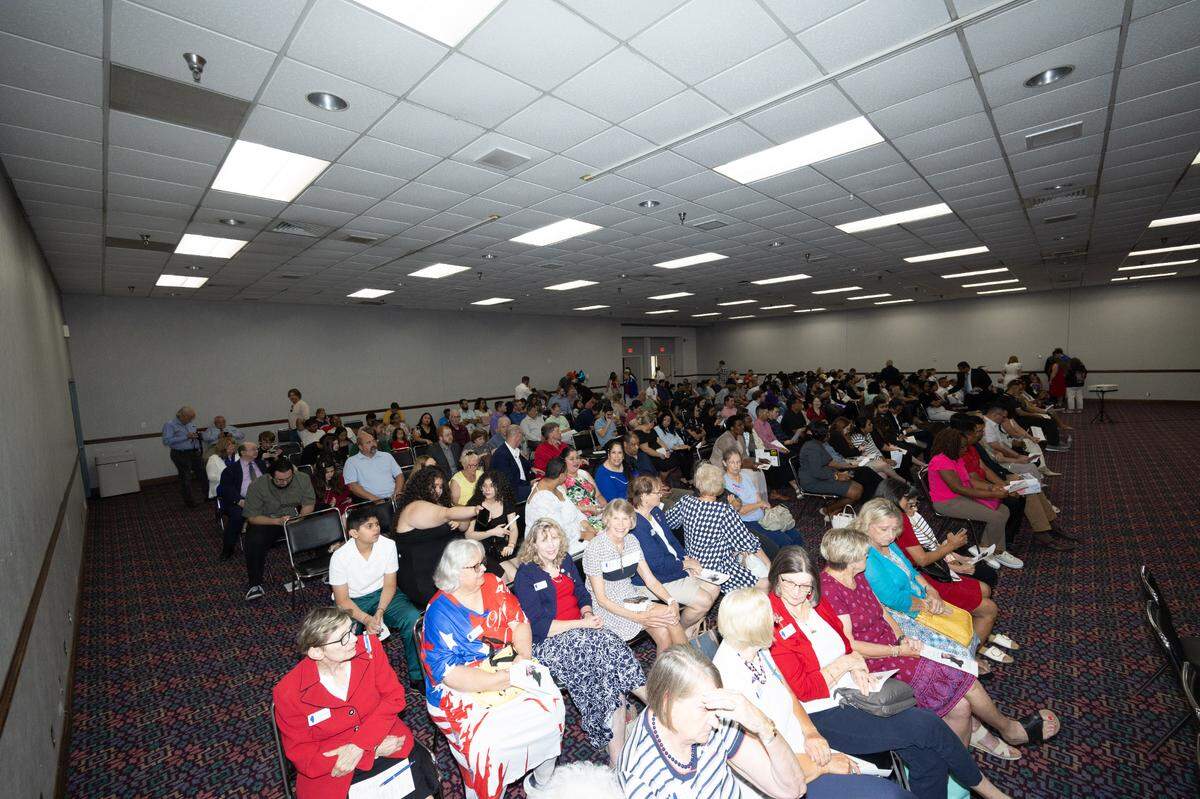 More than 60 people, their families, friends and supporters wait for a at a naturalization ceremony to begin in Collinsville.