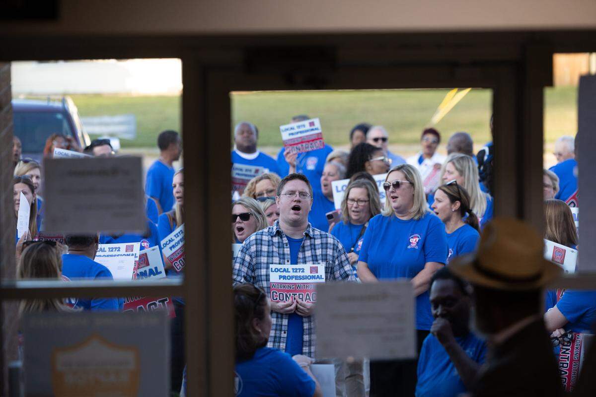 Teachers with local union 1272 line up and chant slogans outside of a school board meeting, where they were kept out due to the meeting room being at capacity. Their chants could be heard throughout the board meeting, especially when the doors were open.