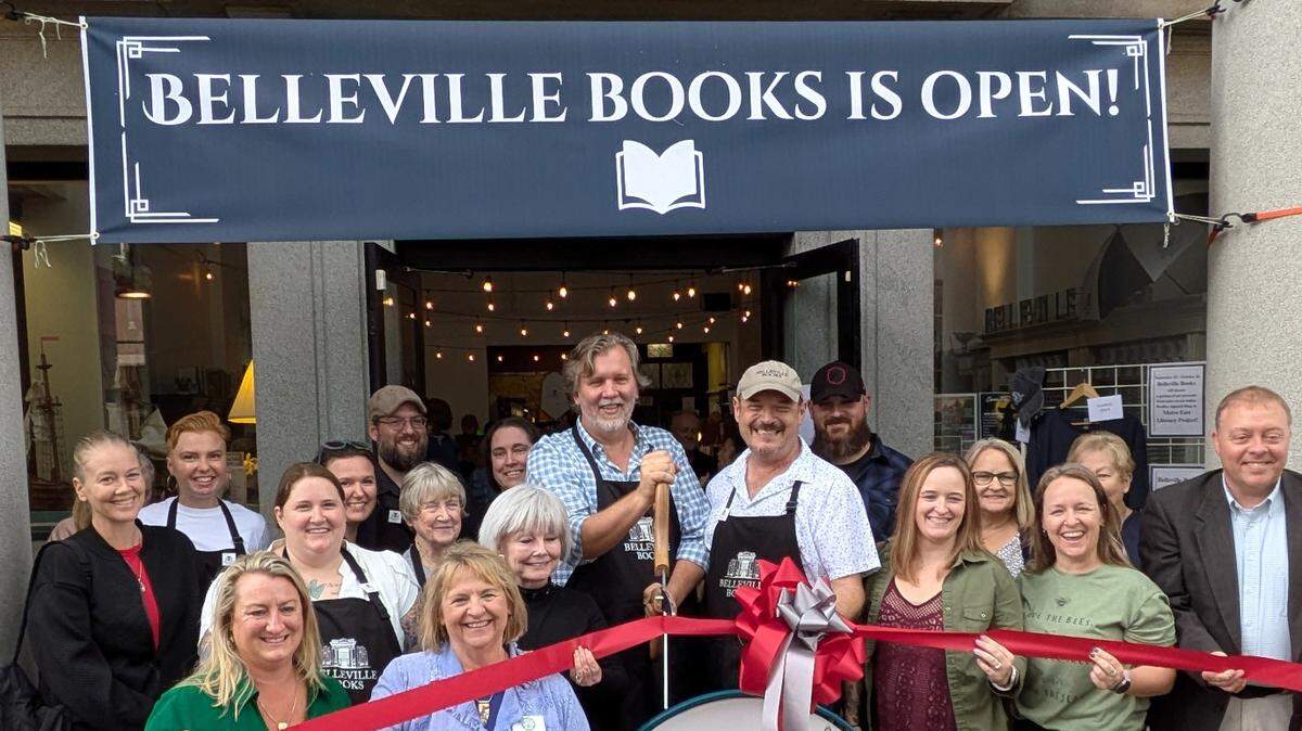 Belleville Books ribbon cutting. At center: owners Steve Mathews (holding scissors) and Rob Eckman