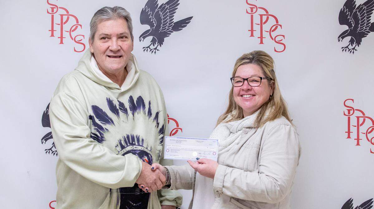 Sam Houston accepts the Queen of Hearts check Friday from Lori Matzenbacher, principal of Saints Peter and Paul Catholic School, which conducted the Queen of Hearts raffle that Houston won Tuesday night in Waterloo.