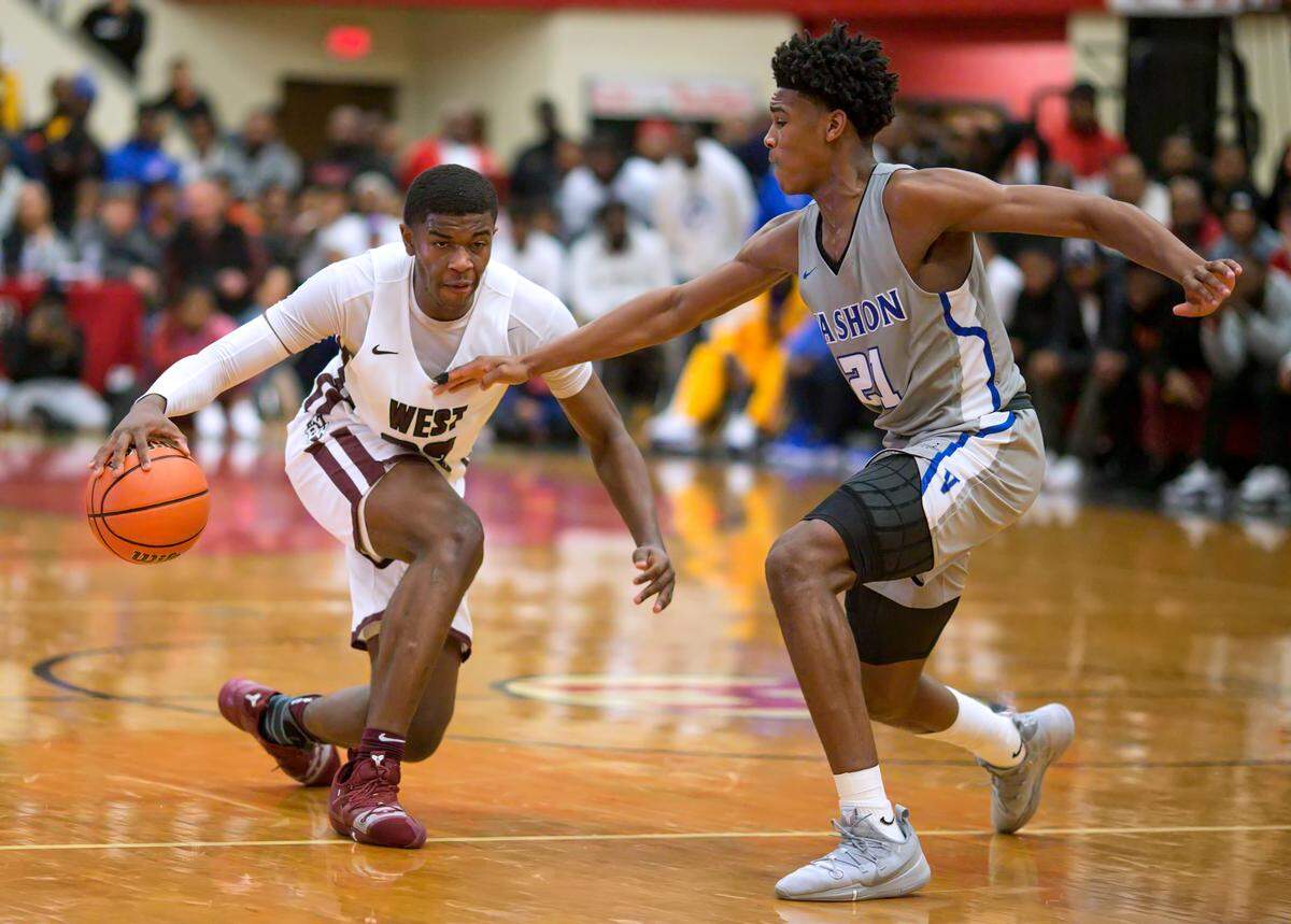 Belleville West senior EJ Liddell drives against Vashon Cam’Ron Fletcher during the Highland Scott Credit Union/Optimists Shootout Saturday.