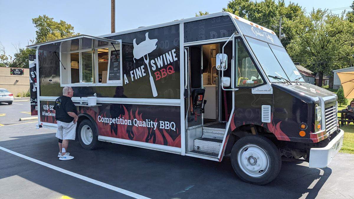 A customer prepares to place an order at A Fine Swine BBQ food truck at the Soulcial Kitchen food truck park in Swansea.