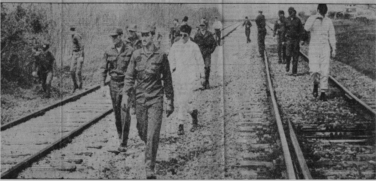 Volunteers from Scott Air Force Base search along the railroad tracks for Kevin Sales.