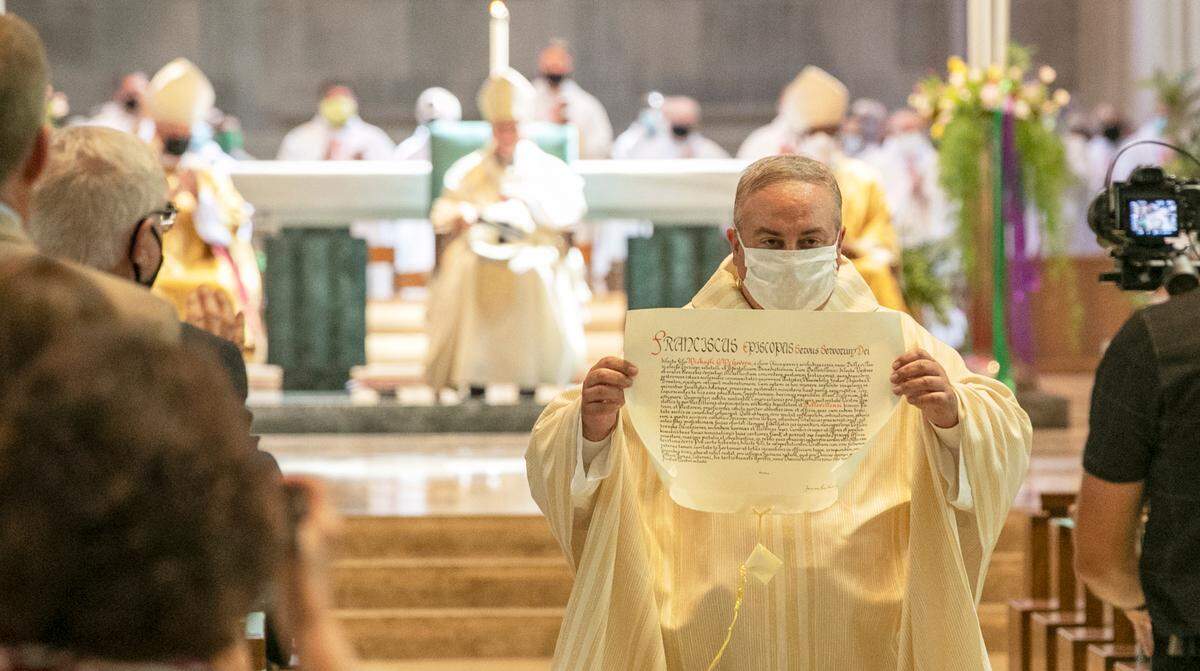 The Most Rev. Michael G. McGovern holds up a letter from Pope Francis, appointing him as the ninth bishop of the Catholic Diocese of Belleville at his Mass of ordination and installation on Wednesday at the Cathedral of St. Peter in Belleville.