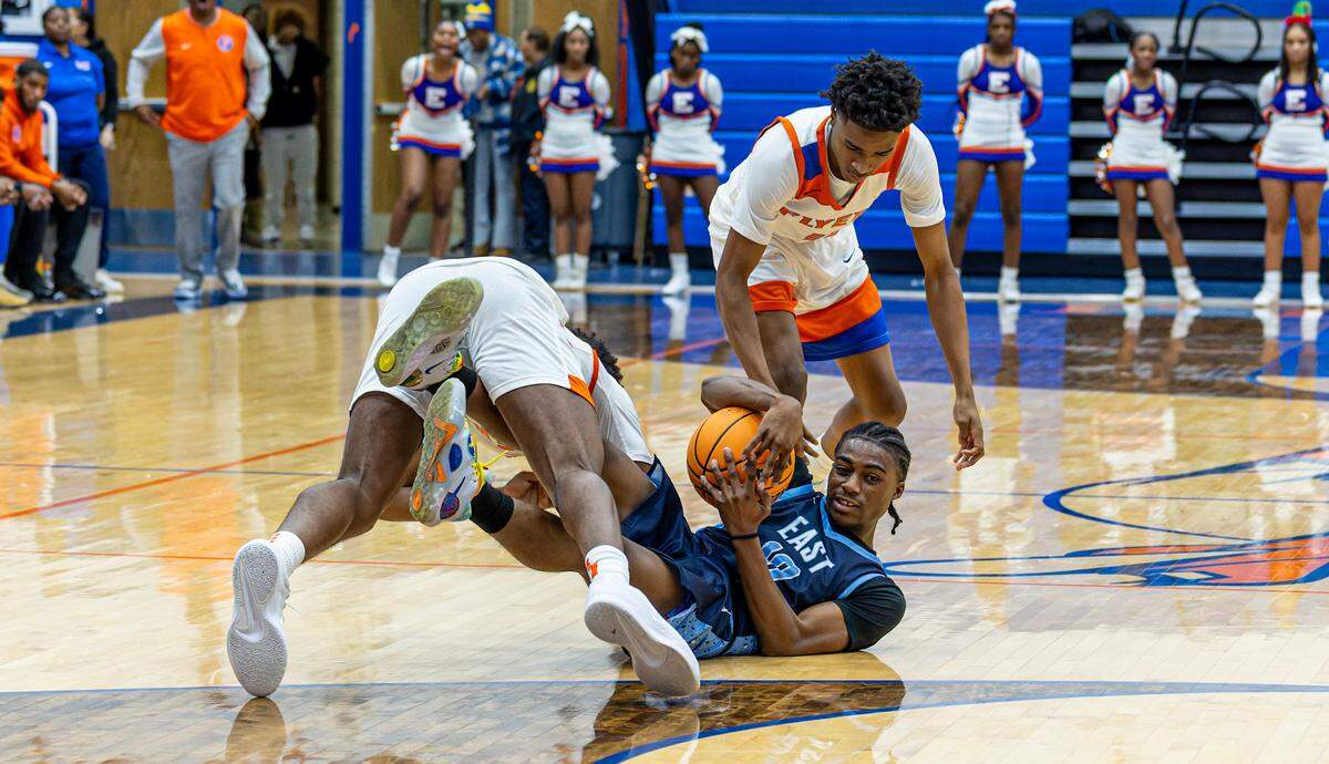 Belleville East’s Kenny Wilson fights East St. Louis defenders for a loose ball.