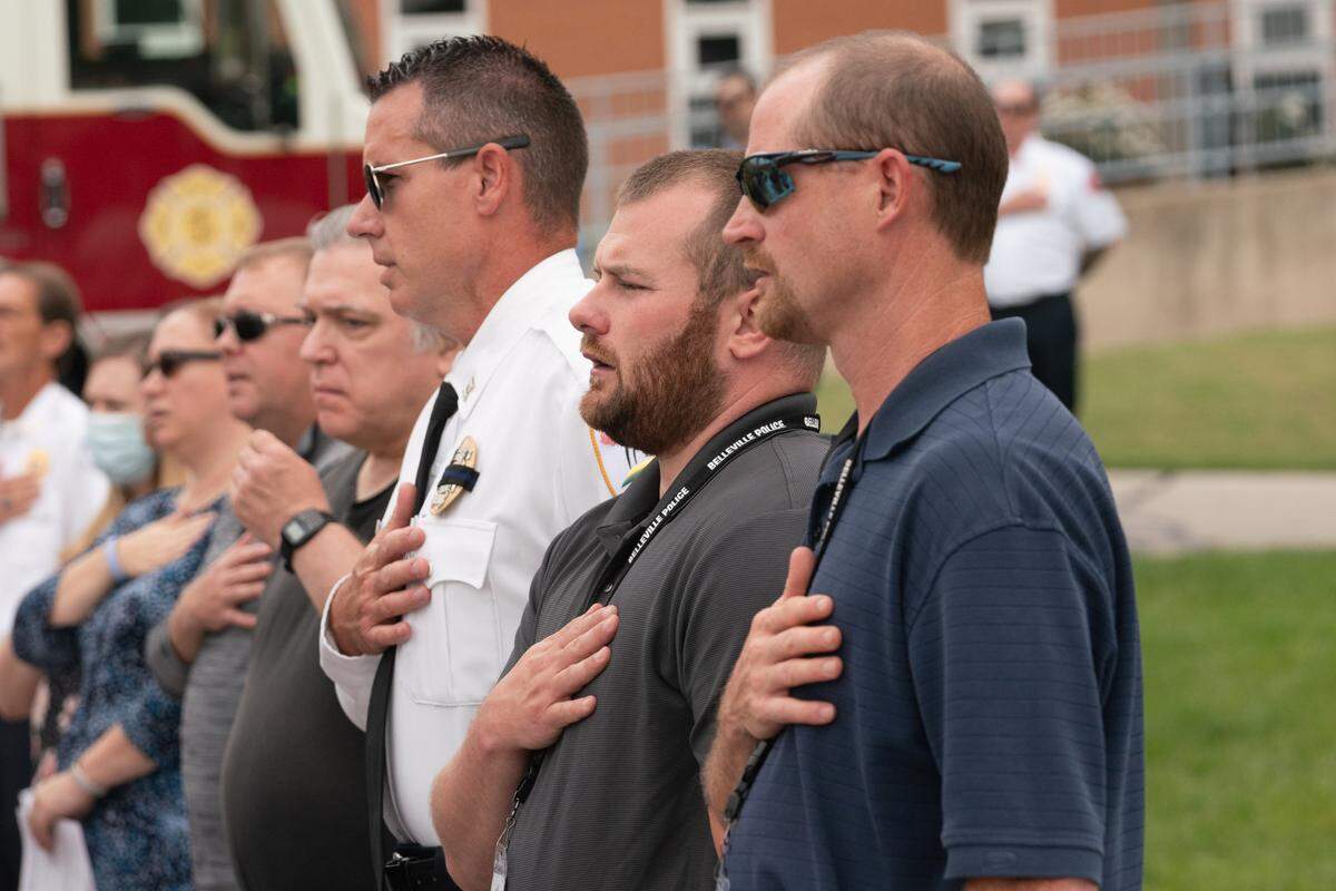Members of Belleville’s police department place hands over their chests for the Pledge of Allegiance on Sept. 11, 2023.