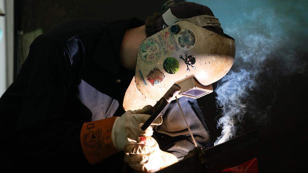 A representative from East St. Louis’s steamfitter union shows a student how to cut a pipe at a construction exposition in Belleville’s Bell-Clair Fairgrounds on Oct. 26, 2023.