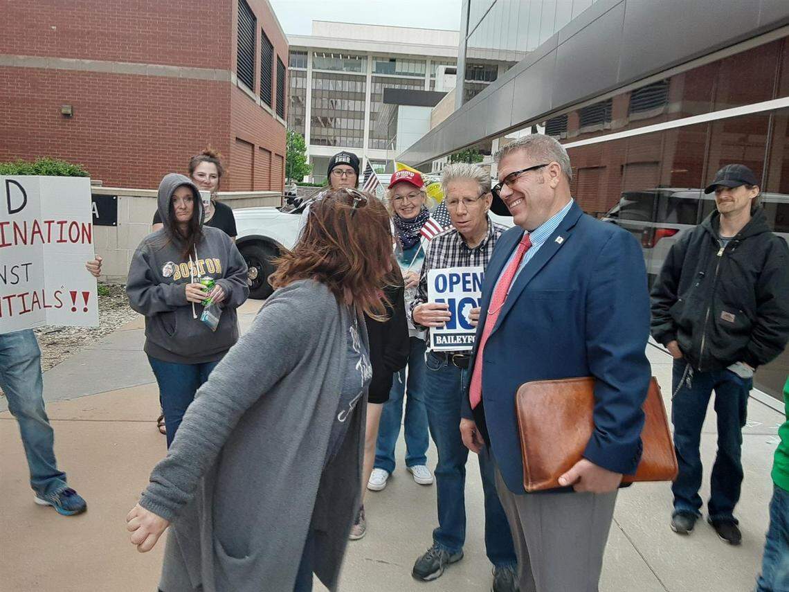 State Rep. Darren Bailey talks with protesters outside the Bank of Springfield Center after he was removed by a House vote for refusing to wear a face covering during the session going on inside the arena May 20, 2020.