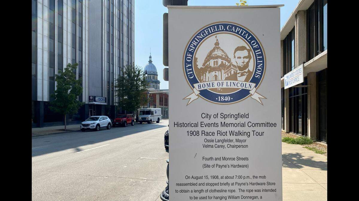 IMAGE: A sign for a Springfield walking tour commemorates the city’s 1908 race riot, just blocks away from the Capitol. On Friday, President Joe Biden designated part of the riot location a national monument.
