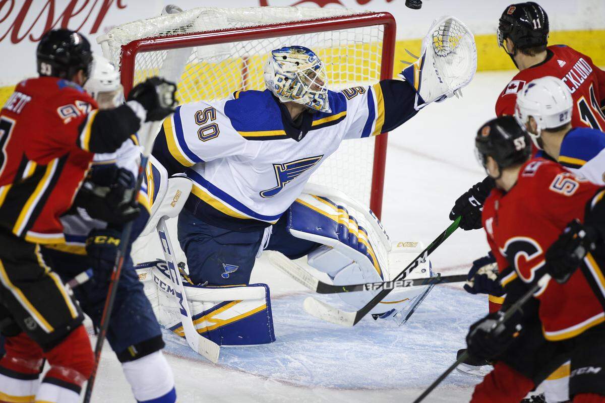St. Louis Blues goalie Jordan Binnington, center, grabs for the puck as Calgary Flames look on during the first period of a game in 2020. In the latest BND poll, we’re asking readers what their favorite sports month of the year is, to include October when the NHL season starts.