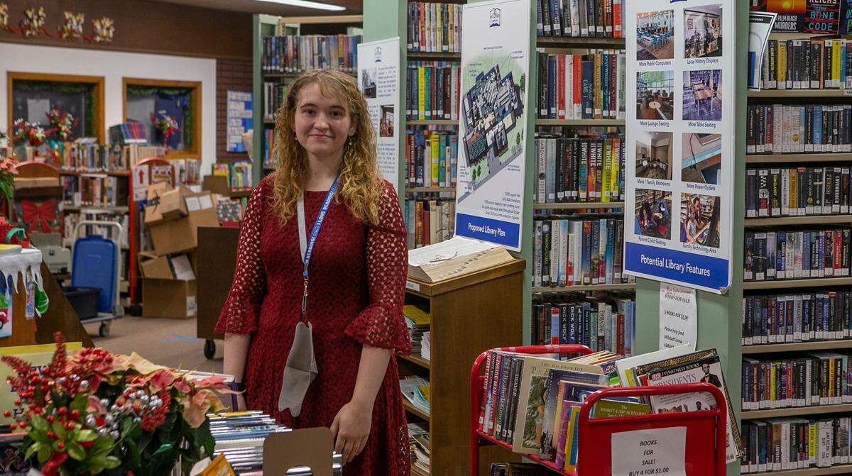 Director Nichole Lauko stands in the crowded, one-room Millstadt Library, surrounded by books, magazines, archival and reference materials, CDs and DVDs.
