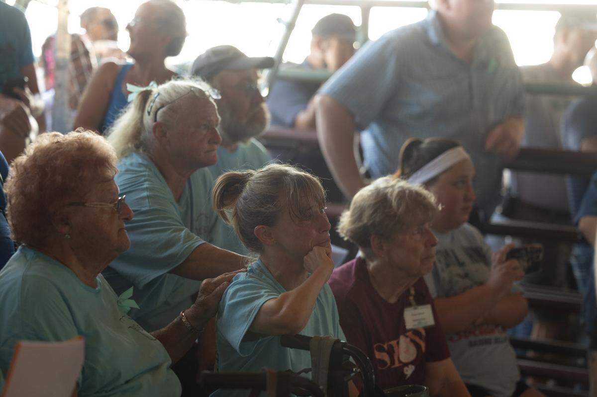 Emma Schultheis’ family, alongside several others from the Monroe County area, pay tribute to the Prarie Du Rocher teen during the county fair’s FFA and 4H livestock auction in Waterloo. Emma’s mother, Amanda, is pictured second from left in the front row. Emma’s father David Anthony was unable to attend the event.