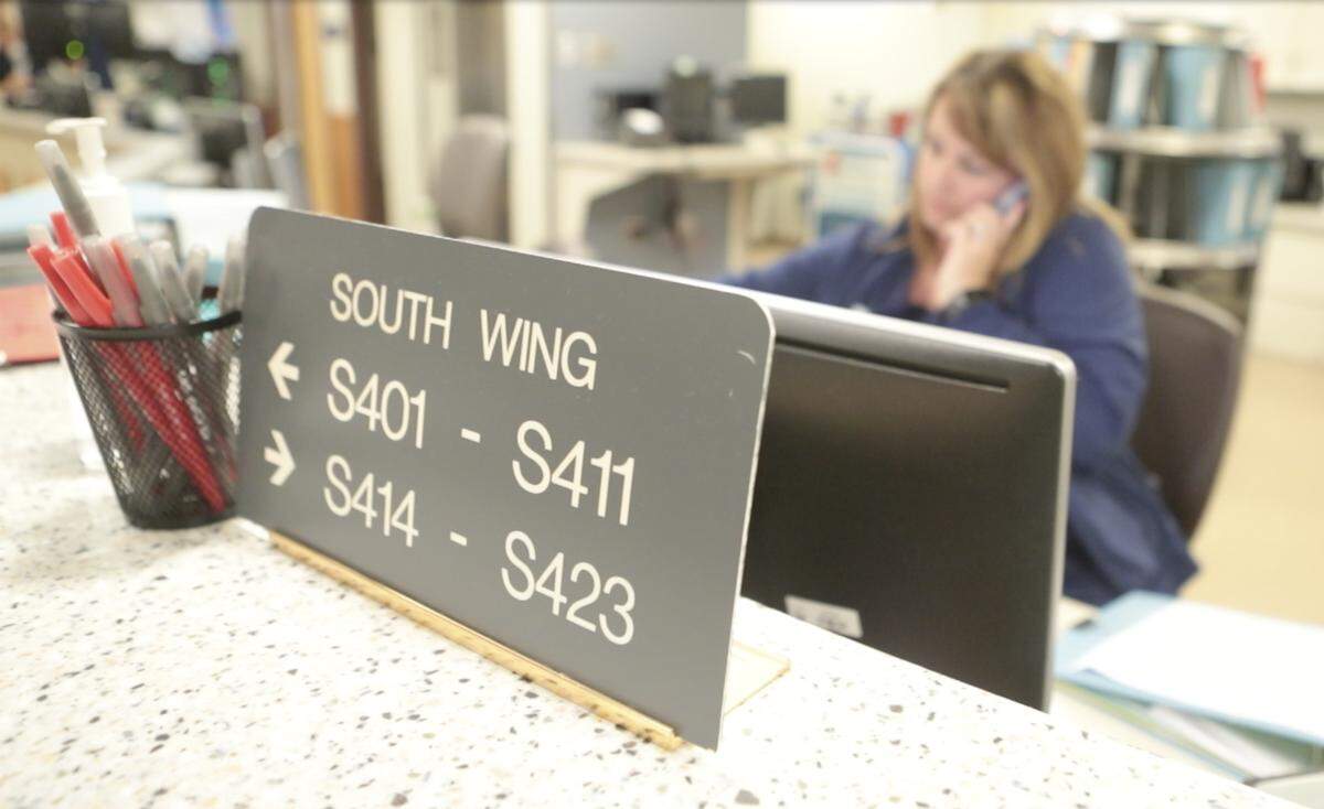 A Memorial Hospital nurse works at the nurse’s station on the fourth floor South Wing patient floor.