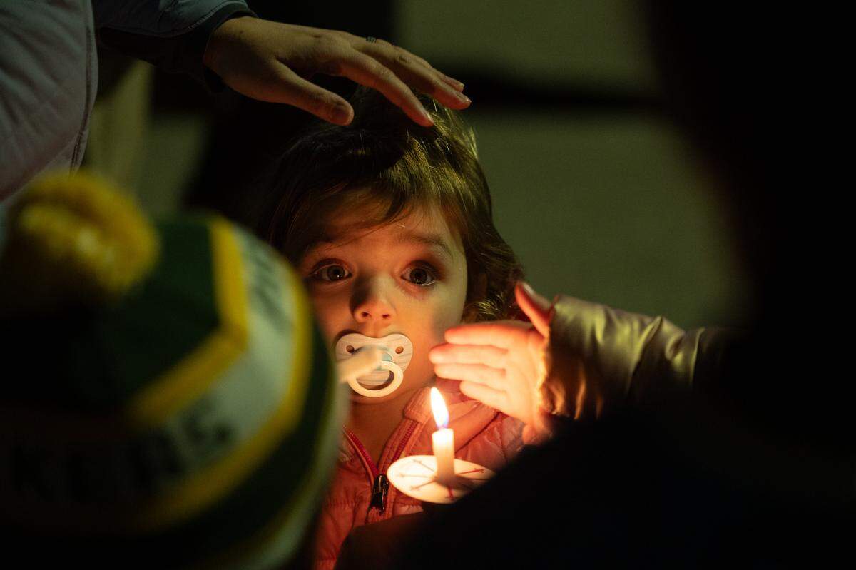 Evelyn Boynton holds a candle with help from her family during a candlelight vigil held in support of O’Fallon’s Colin Brown, 16, who was hit by a stray bullet in his car while going home from a hockey game with his father on I-55 in St. Louis. Friends gathered for the vigil at the McKendree MetroRecplex in O’Fallon Monday.