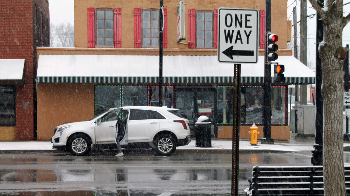A driver prepares to leave Main Street in Collinsville on Saturday, Jan. 15, 2022, as snow falls.