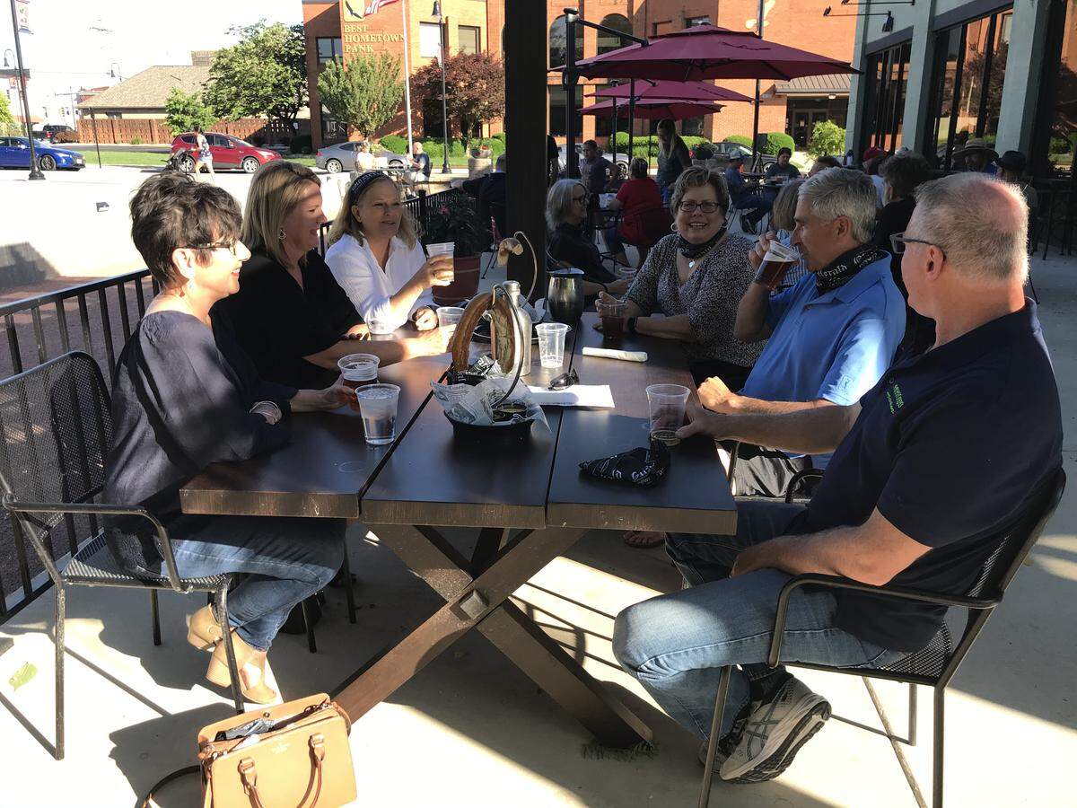 Jeanne Pysz, third from right, makes a joke while visiting with friends on the patio at Old Herald Brewery & Distillery in Collinsville on Friday.