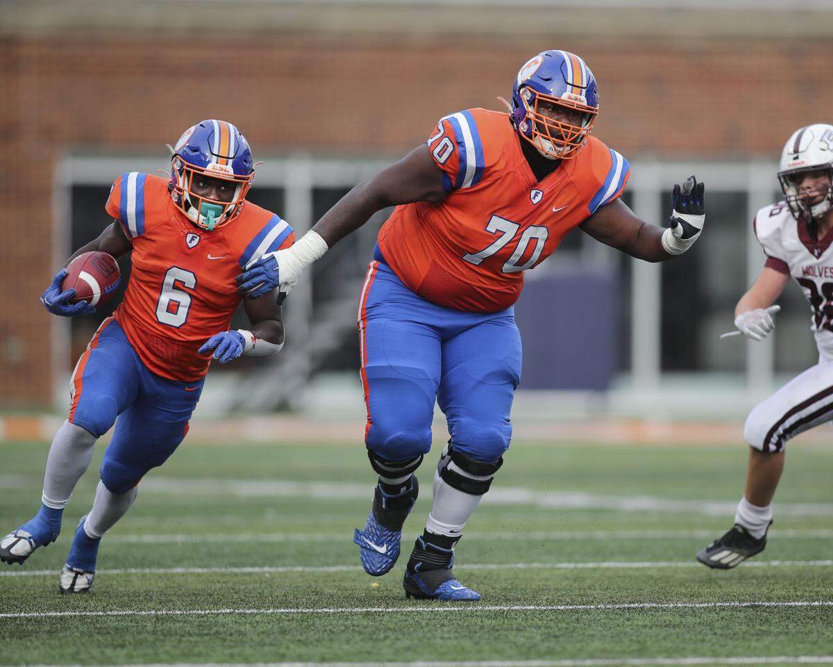 East St. Louis offensive lineman Paris Patterson Jr. leads the way for TaRyan Martin during the IHSA Class 6A state championship game against Prairie Ridge.