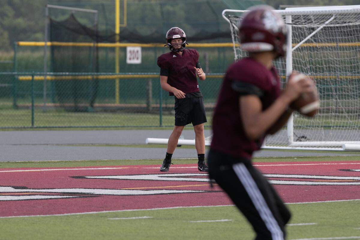 Junior quarterback James Thomas warms up with sophomore quarterback Caiden Capell during football practice at Belleville West on Aug. 19, 2024.
