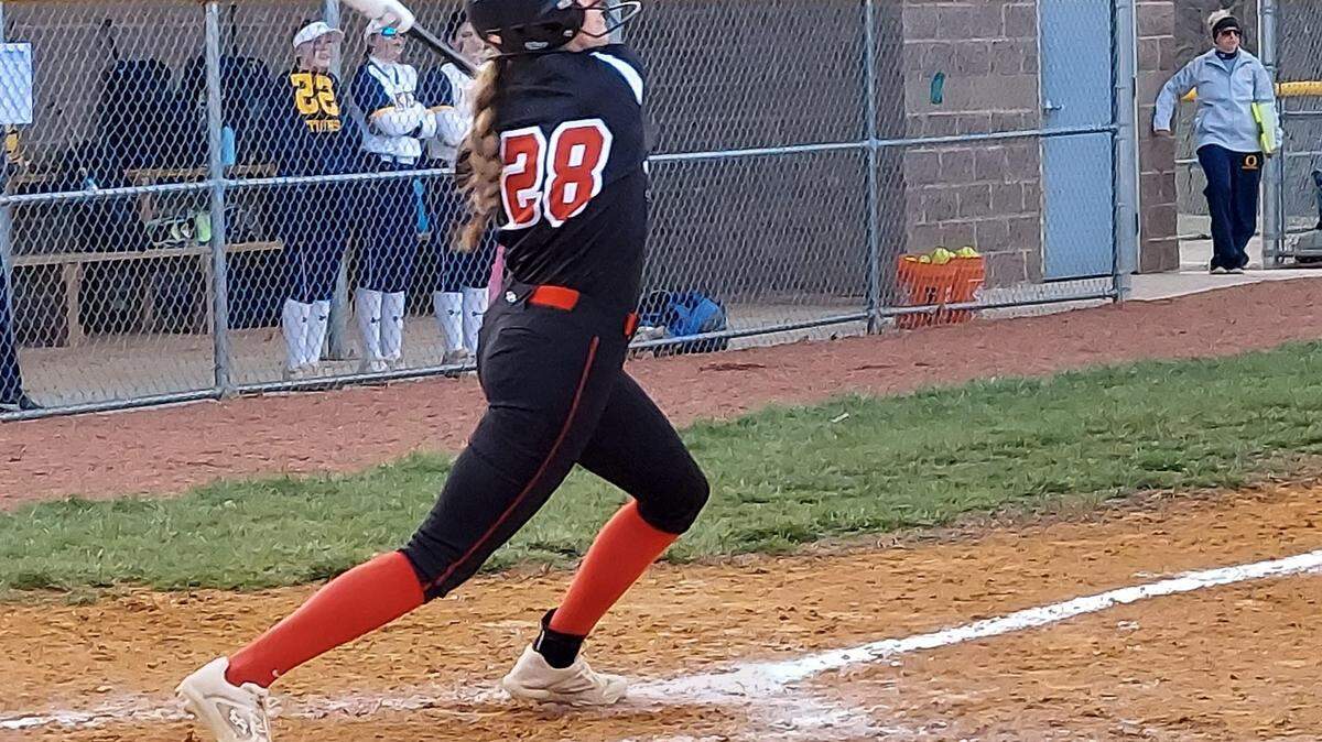 Highland’s Maggie Grohmann rips a shot toward right field during a nonconference softball game in O’Fallon.
