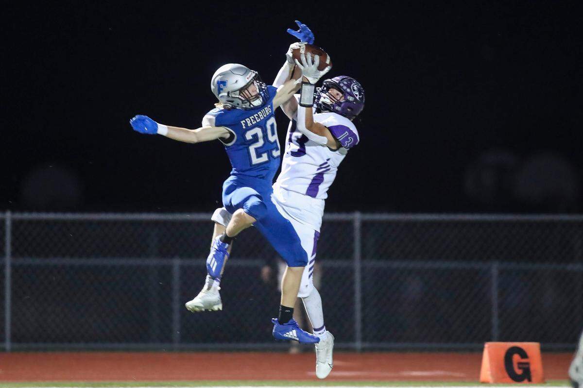 Breese Central’s Braden Revermann (13) hauls in a Conner Freeze touchdown pass against Freeburg on Friday night. The Cougars rallied from a 13-8 halftime deficit to defeat the Midgets 31-19 in the Cahokia Conference opener for both teams.