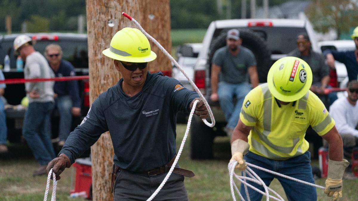 An Ameren lineman prepares to throw a rope over a telephone pole in Belleville, Ill. on Sept. 20, 2023 in preparation for the International Lineman Rodeo.