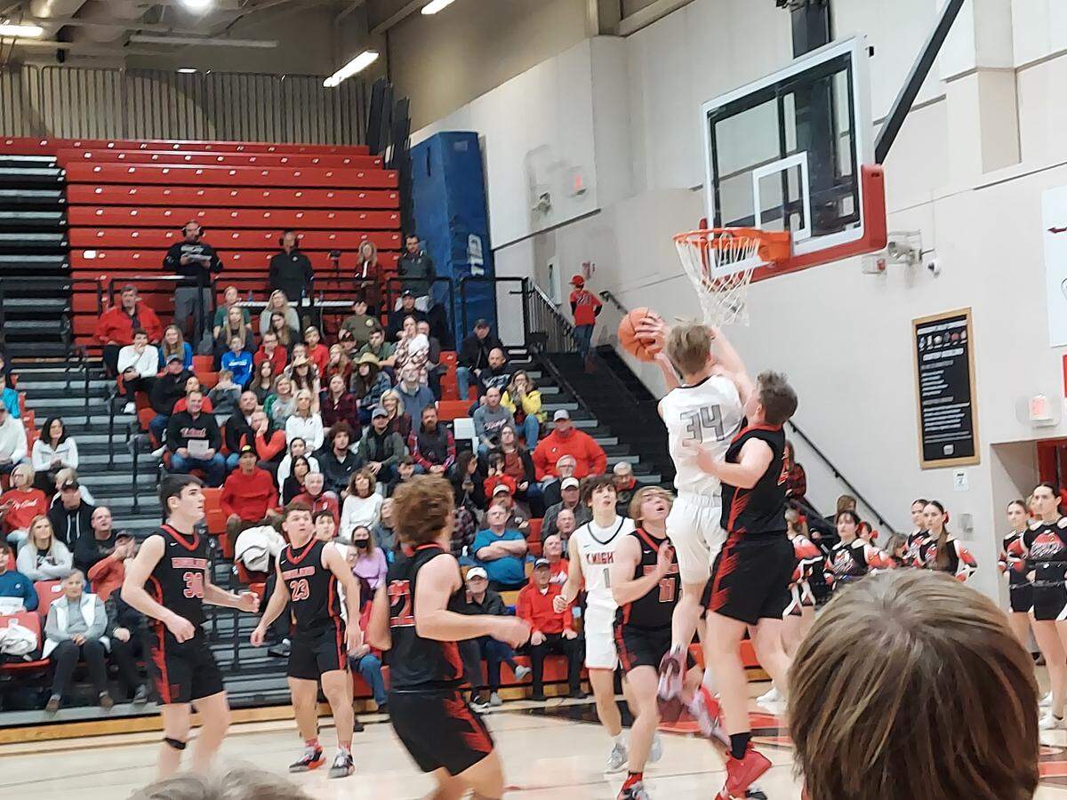 Triad’s Tyler Thompson goes up for a layup over Highland’s Garrin Stone during a Mississippi Valley Conference game at Triad High School on Friday. Stone and the Bulldogs ultimately posted a 51-43 victory.