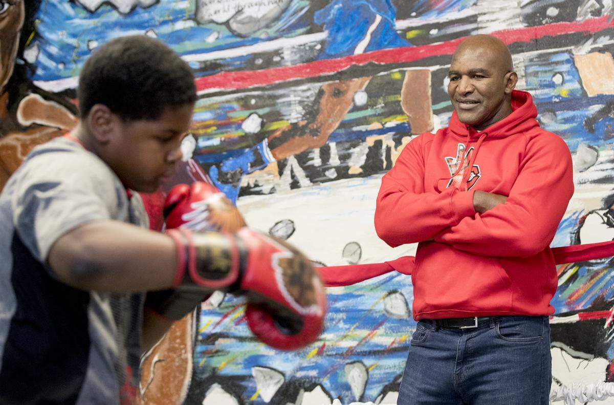Evander Holyfield works with Lumetrick Rose, 10, of East St. Louis.  Holyfield visited with boxers and supporters of Arthur “Flash” Johnson’s new boxing gym in East St. Louis.