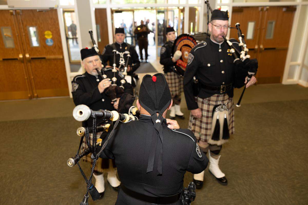 Pipers from St. Louis County Police Department Pipes & Drums lead a procession of police officers in the opening of a memorial service for fallen police officers of St. Clair County in Christ Church on Frank Scott Parkway in Fairview Heights, Ill. on May 7, 2024.