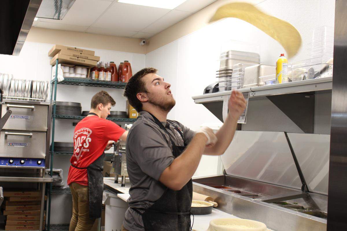 Brady Arbogast, 19, throws pizza dough at Joe’s Pizza & Pasta in Collinsville. Brady is the son of franchise owners David and Sara McMahan.