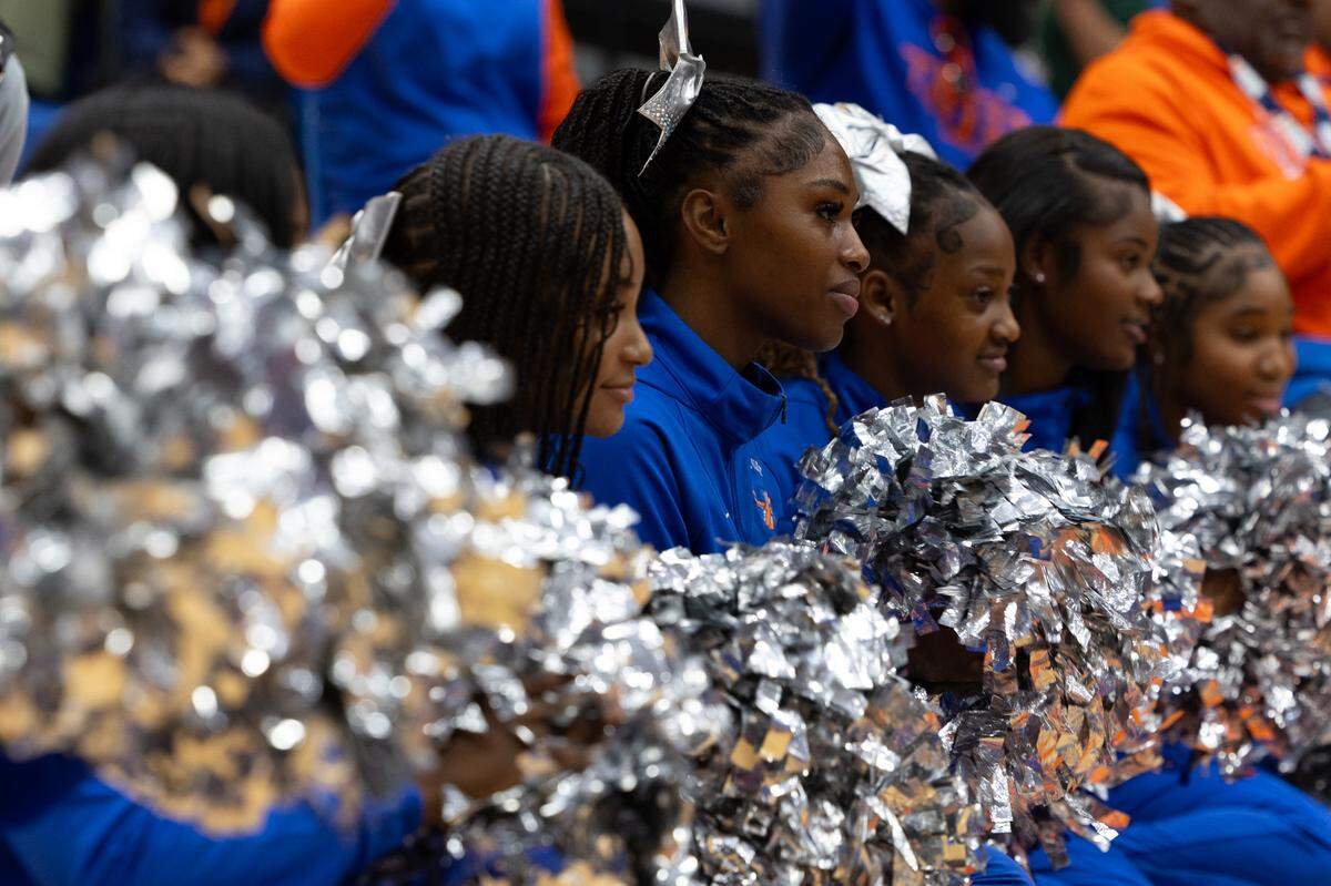 East St. Louis cheerleaders smile and shake pom-poms after a shout out from head football coach Darren Sunkett.