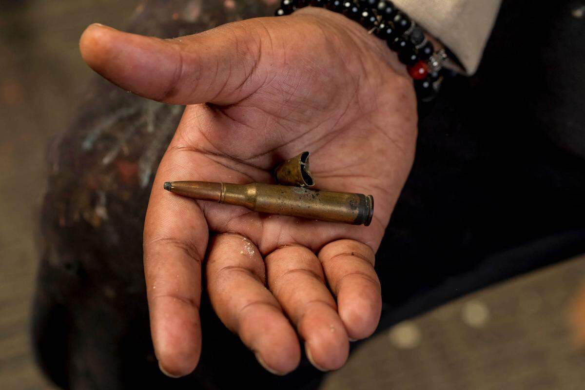 Mykael Ash holds bullet shells he found on the streets of East St. Louis, Illinois, at his studio. Ash uses bullet shells and other objects he finds on the ground in his artwork. (Whitney Curtis for KHN)