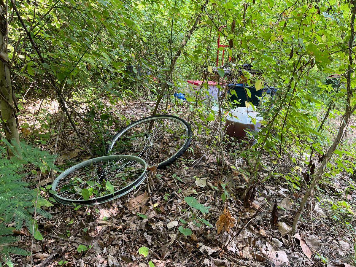 A squatters camp along the MetroBikeLink Trail in Swansea includes bicycle wheels and tubs of clothing. Many people living in such camps use bikes for transportation because they don’t own cars.