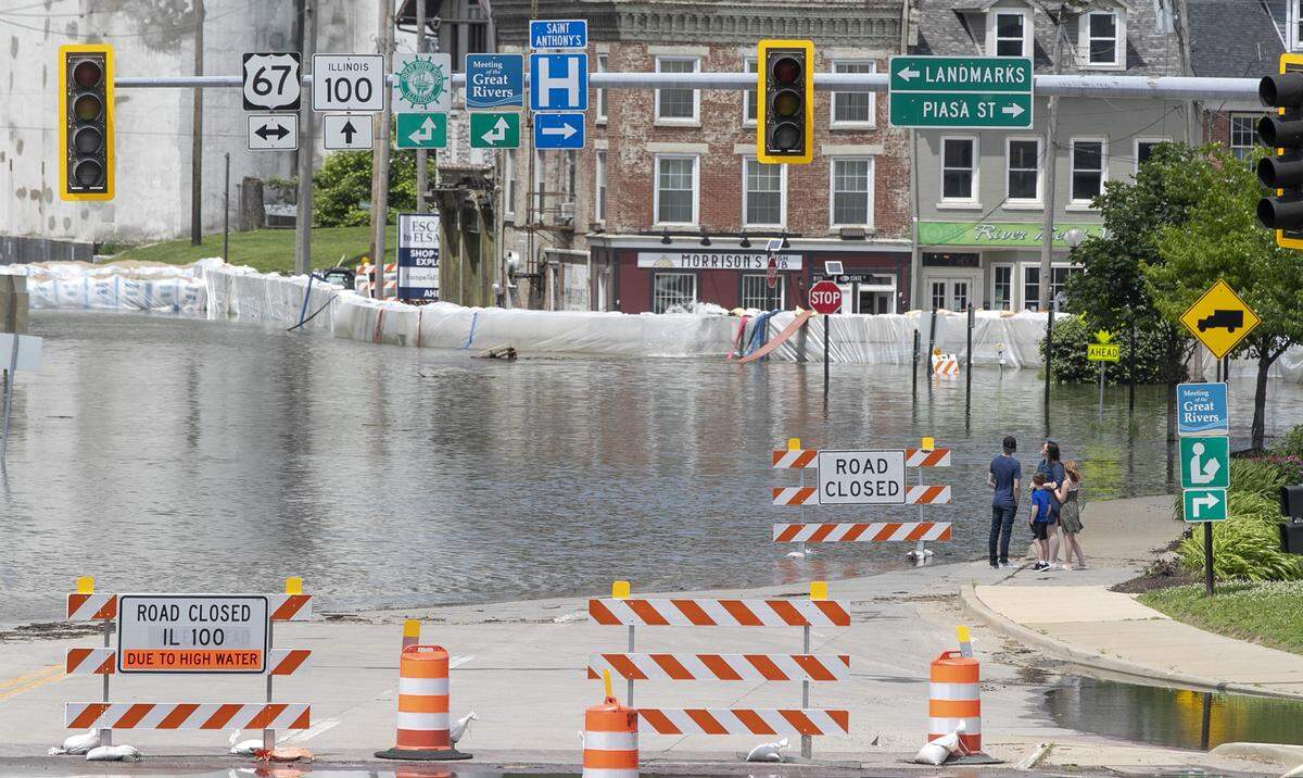 A family takes a look at the flooding in Alton at the intersection of Illinois 100 and U.S. 67.