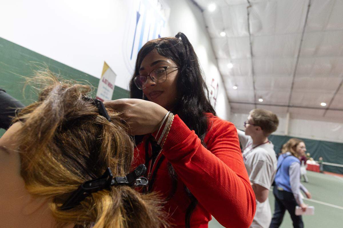 Miley Jones a senior at Belleville West, practices hairdressing on a mannequin during a career fair at The CAVE.