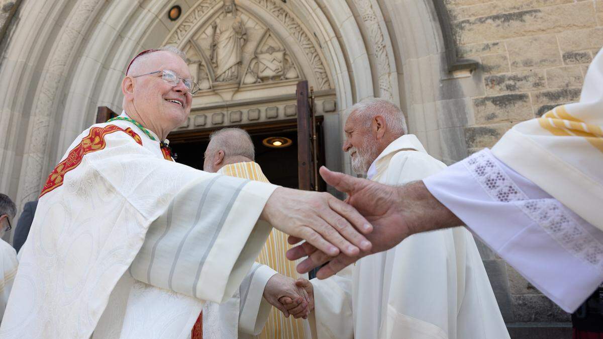 Bishop Godfrey Mullen shakes hands with clergy outside the Cathedral of St. Peter after his installation as the 10th bishop of Belleville on Friday.