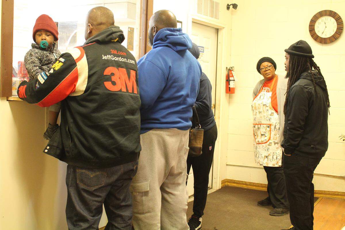 The lunchtime crowd on a recent weekday at Good Heavens BBQ & Bakery in East St. Louis includes, left to right, customers Stephon Williams, DeMario Ellison, Stanley Williams, Renisha Williams and Ronnie Dillard, who is talking to volunteer Lorene Crockett in the apron.
