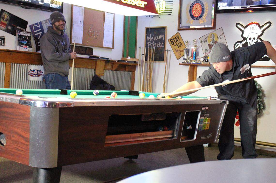 Michael Frazier, left, and Nathan Boyer play pool at Big O’s bar and restaurant in Madison during their lunch break from Maverick Transportation across the street.