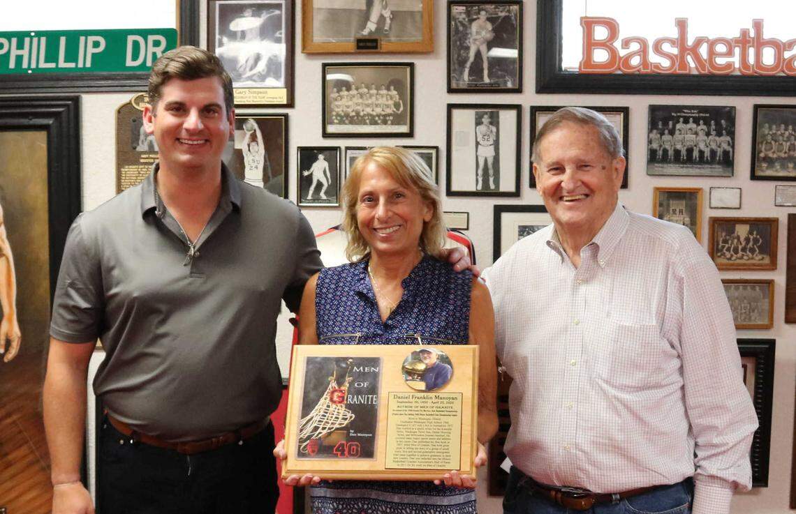 Randall Manoyan, left, his mother, Christine, and retired teacher and coach Babe Champion show off a plaque for the late Dan Manoyan, author of “Men of Granite,” after a meeting Saturday at the Granite City Sports Hall of Fame.