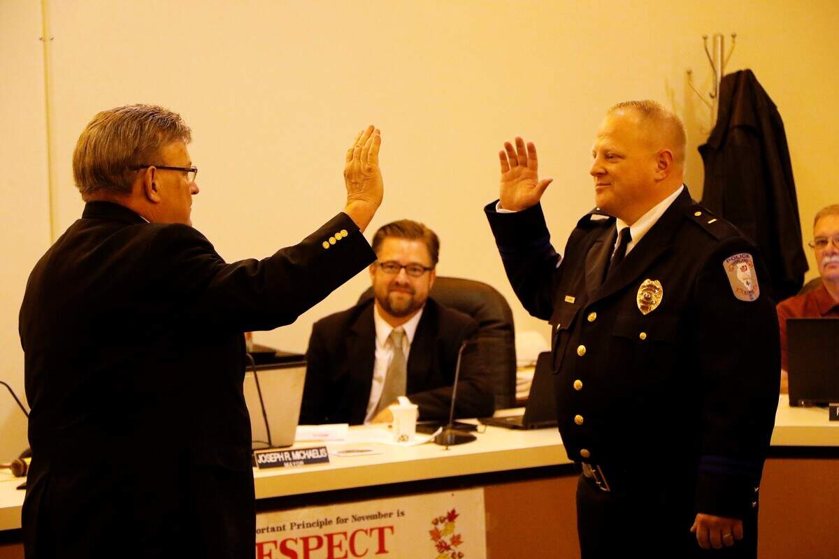 Highland Mayor Joe Michaelis swears in new Police Chief Chris Conrad at a meeting of the city council Monday, Nov. 19.