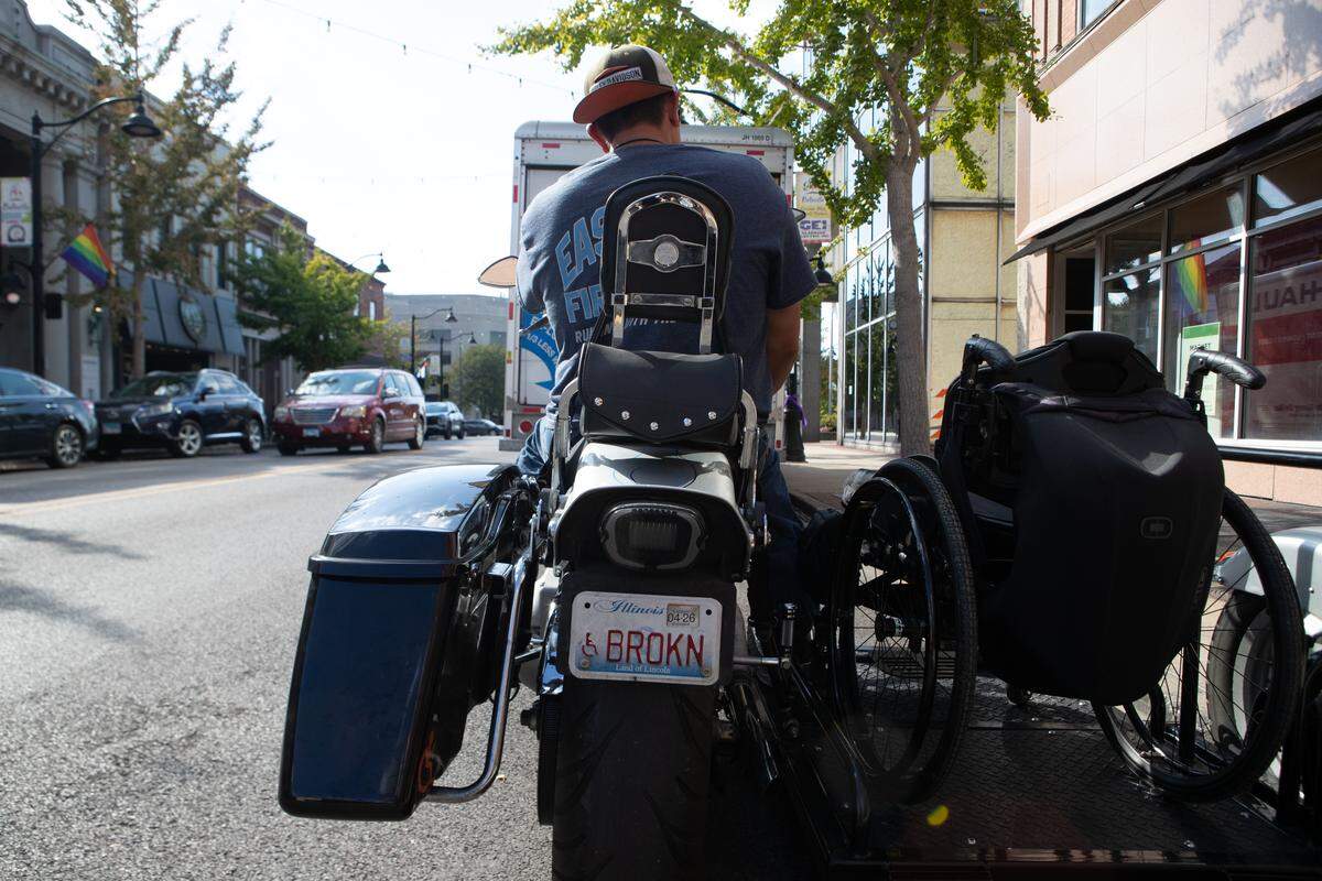 Brad Henke sits on the his motorcycle before leaving Belleville’s Main St. with his handicapped “BROKN” license plate in view. “You just gotta laugh about it,” Henke said. “What else can you do?”