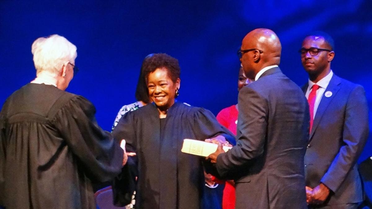Justice Mary Jane Theis, left, administers the oath of office to Lisa Holder White, making her the first Black woman to serve on the Illinois Supreme Court. Holder White’s husband, James White, holds a Bible while their son, Brett, White looks on.