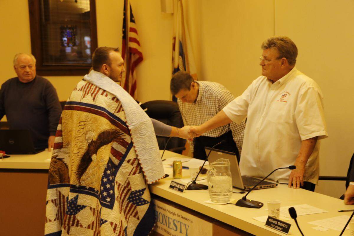 Highland veteran Logan Wolf shakes Mayor Joe Michaelis’ hand after being honored with a Quilt of Valor.