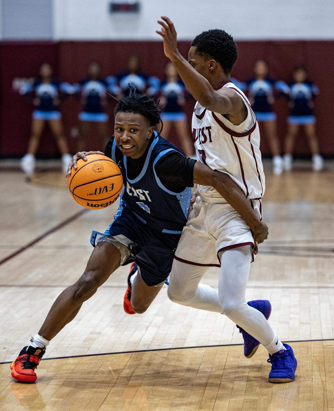 Belleville East’s Jalen Coleman dribbles around a Belleville West defender Friday.