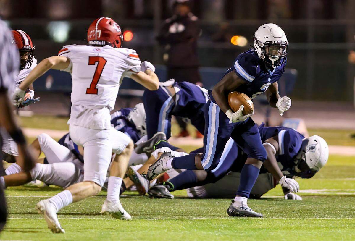 Belleville East’s Markevious Curiton runs the ball during Friday’s non-conference game against Granite City. The Lancers prevailed to become playoff eligible.
