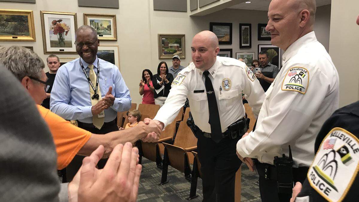 Belleville Ward 7 Alderman Dennis Weygandt, far left in orange, shakes hands with Capt. Mark Heffernan, who was promoted to assistant police chief at a City Council meeting on Monday night. Looking on are Police Chief Bill Clay, left, who will become director of human resources; and Assistant Police Chief Matt Eiskant, who is taking Clay’s place.