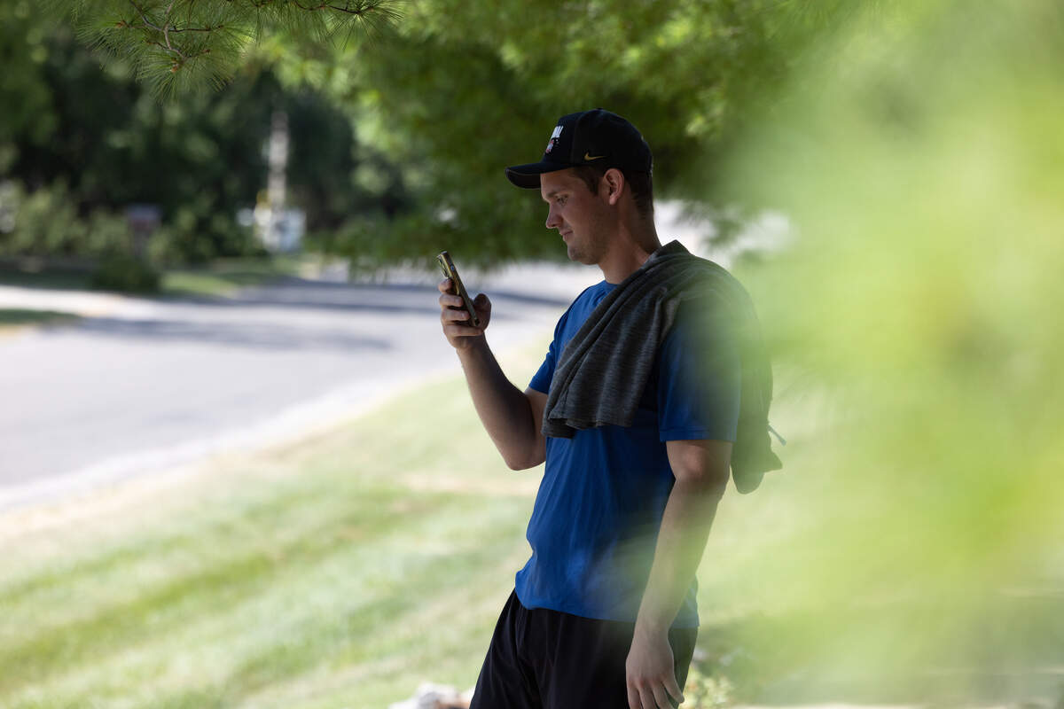 A local resident snaps a photo during a standoff in the 1800 block of Meadows Dr. in Columbia, Ill.