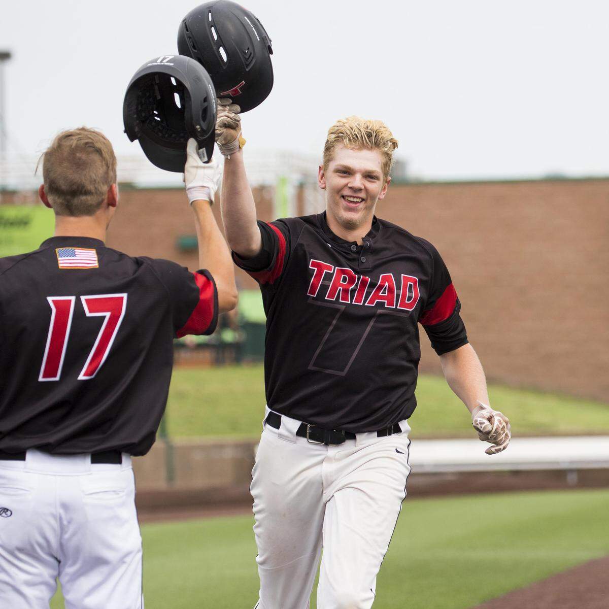 Triad's Travis Heilmann is congratulated by Joe Wade after after his home run in the 3A Super Sectional in Sauget.