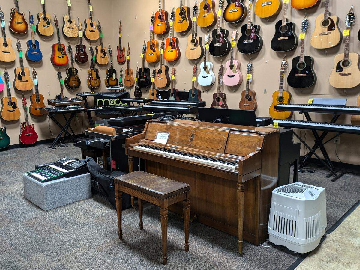 Guitars, keyboards and a Wurlitzer player piano (center front) at Swing City Music in Collinsville